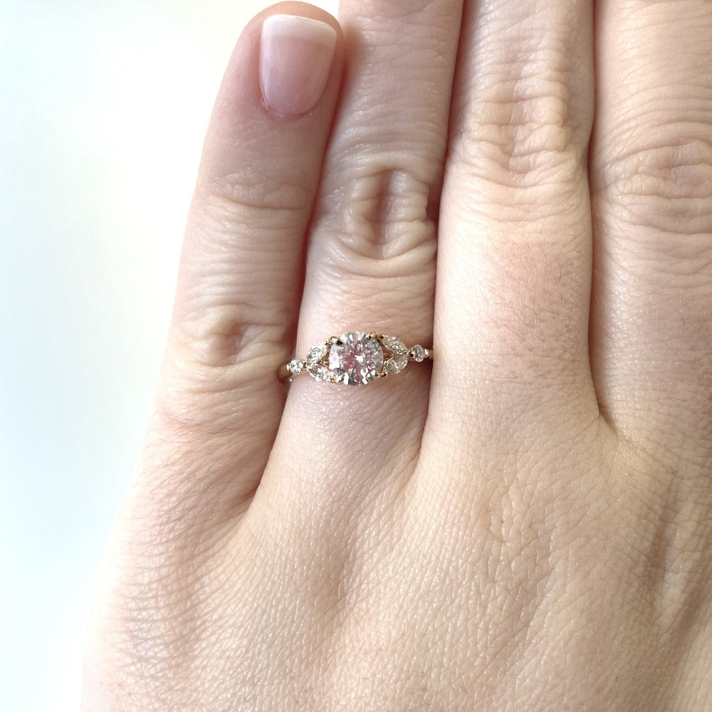 up close detail view of 14ky round and marquise diamond ring on model's hand