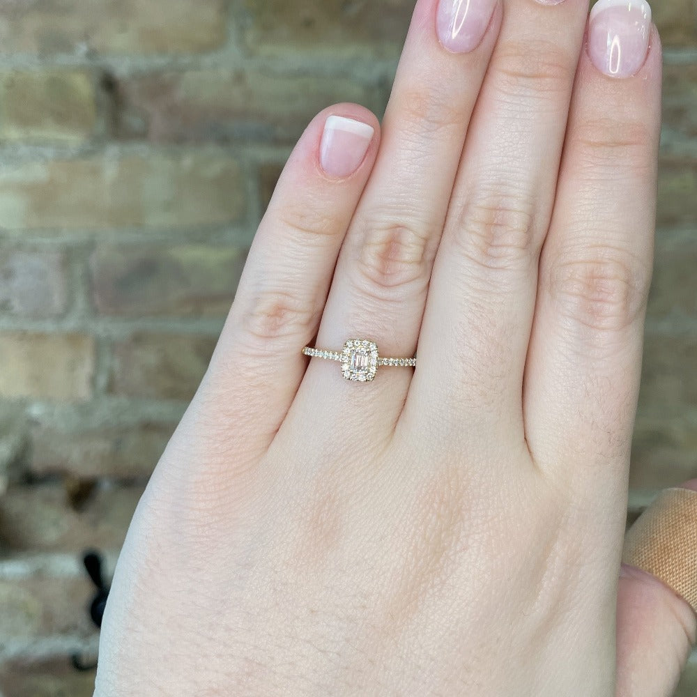 14ky halo style engagement ring with emerald cut center on model