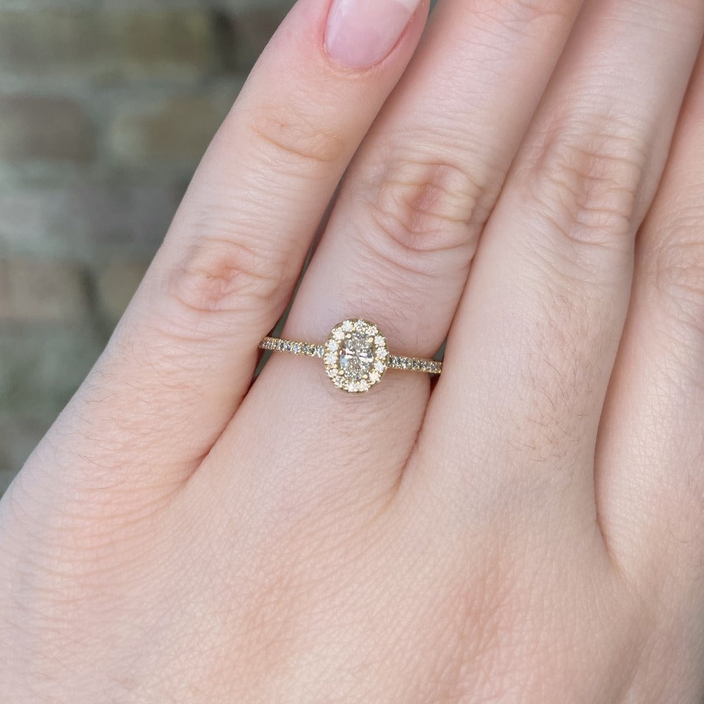 closer view of 14ky oval halo style engagement ring on model