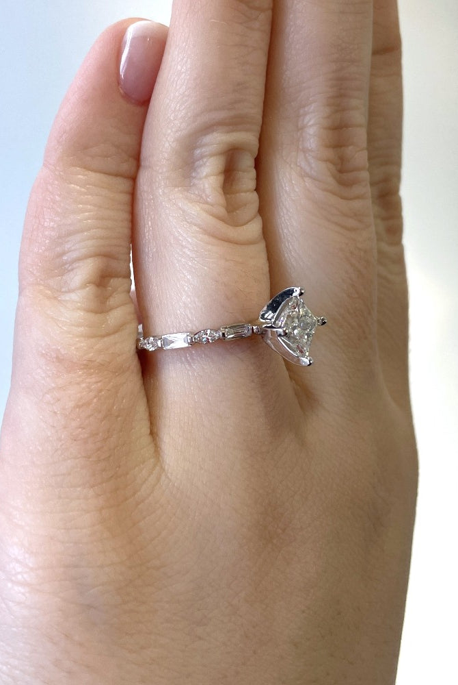 side view of 14kw princess cut diamond engagement ring. picture shows the marquise and baguette diamond accents on band.