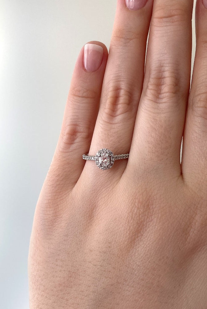 14kw Oval cut halo style engagement ring on model