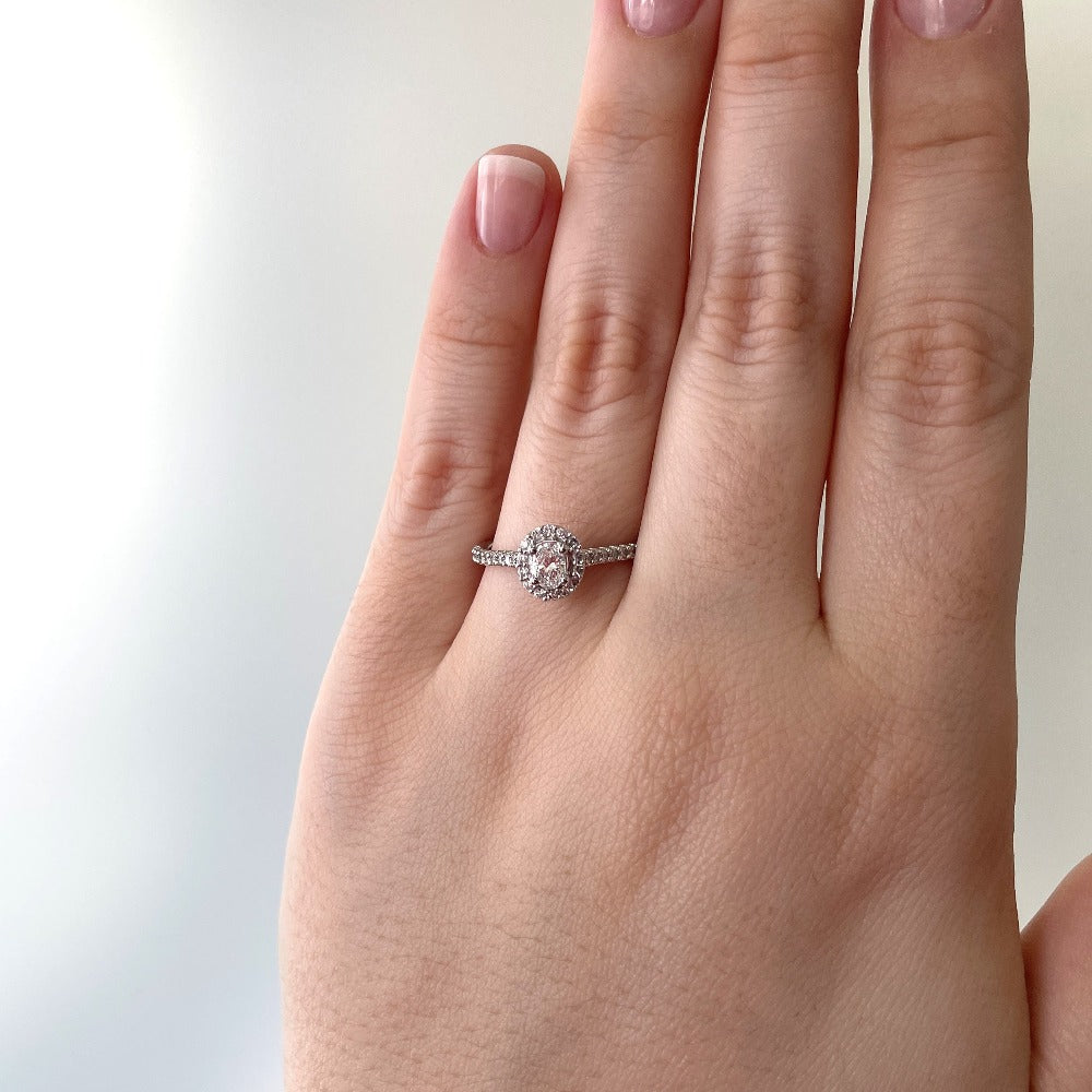 14kw Oval cut halo style engagement ring on model