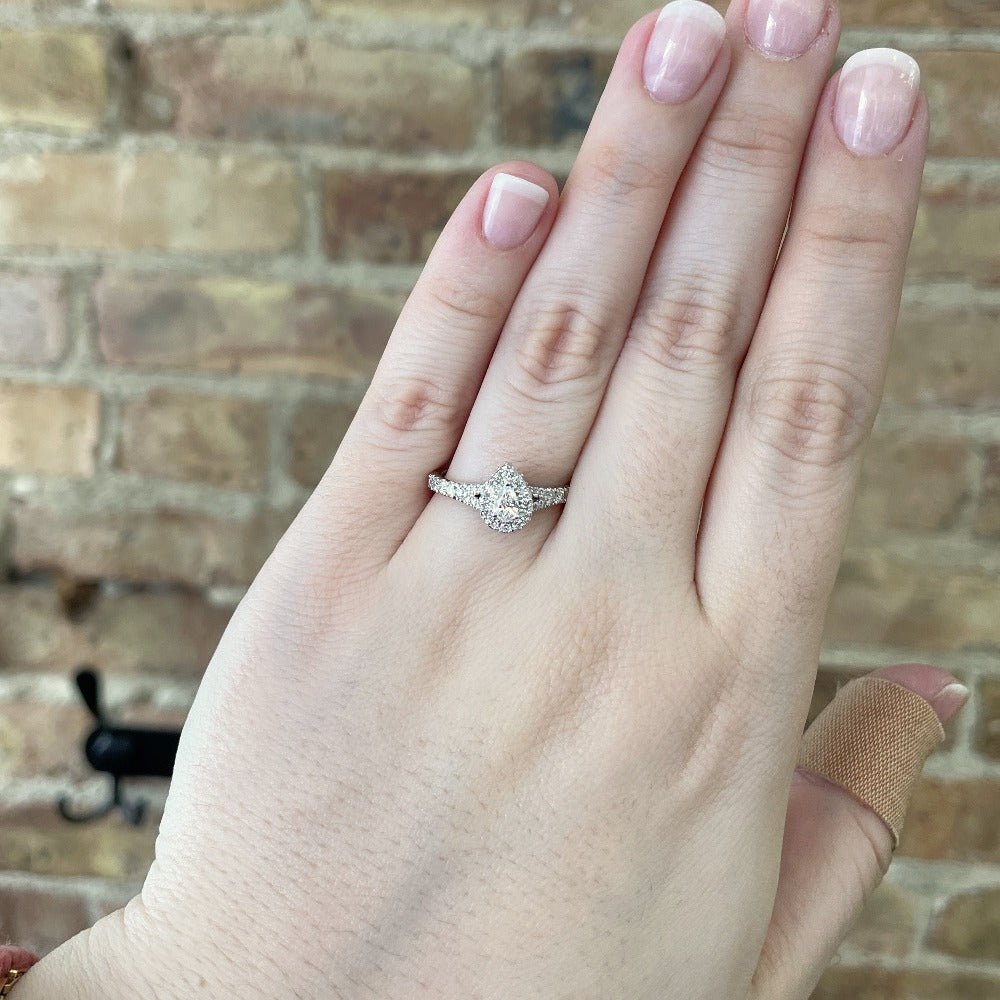 14kw pear cut halo style engagement ring with split shank on model.