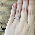 view of 14kw halo style engagement ring with twisted shank on model