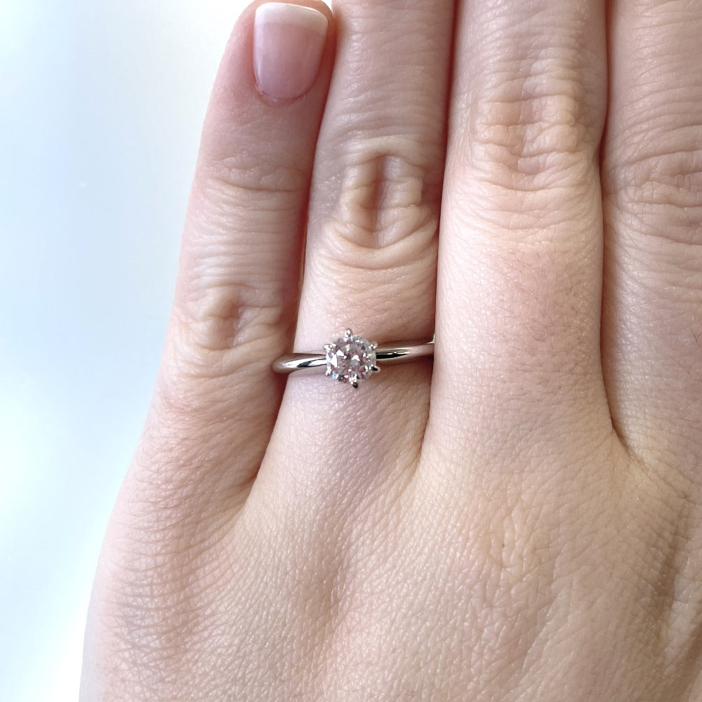 14kw .46ct round diamond solitaire engagement ring on model's hand