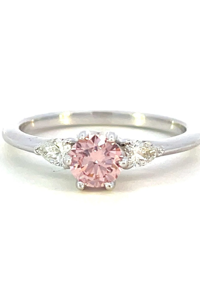 a detail view of 14kw pink diamond engagement ring with pear accent stones.