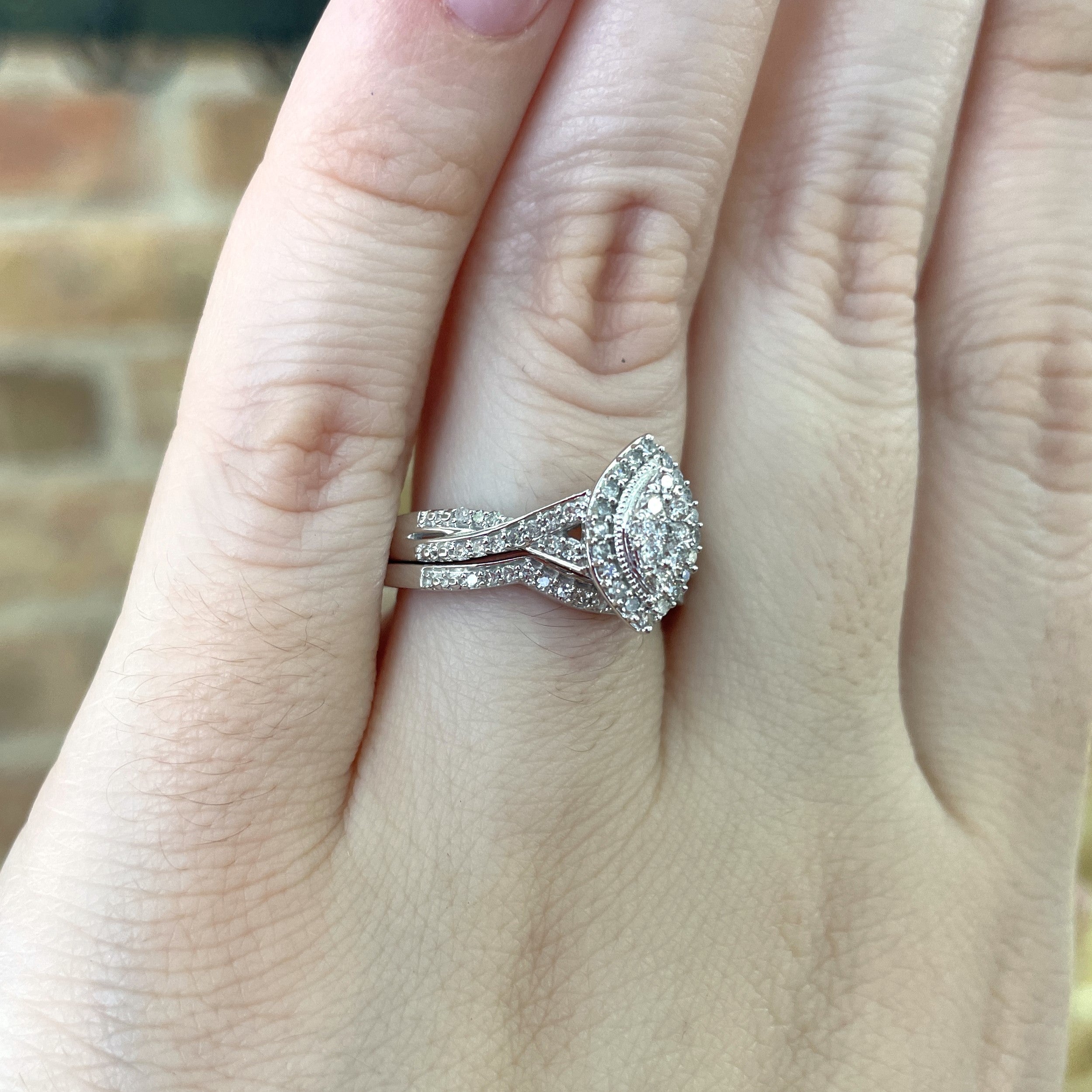 view of side details of wedding set shown on models hand.