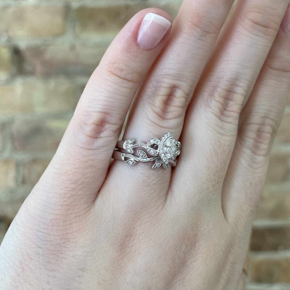 side view of 14kw floral inspired wedding set with marquise cut center on model