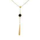 detail view of 14k yellow gold "Y" style necklace with bezel set black onyx drop and gold tear shaped dangle
