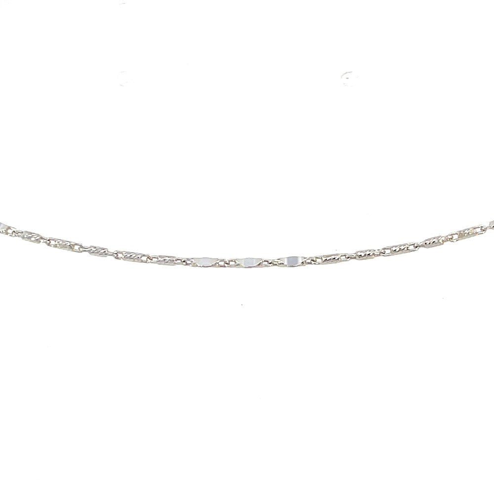 detail view of 14k white gold anklet showing the pattern of 3 flat stations and 5 diamond cut barrel links.