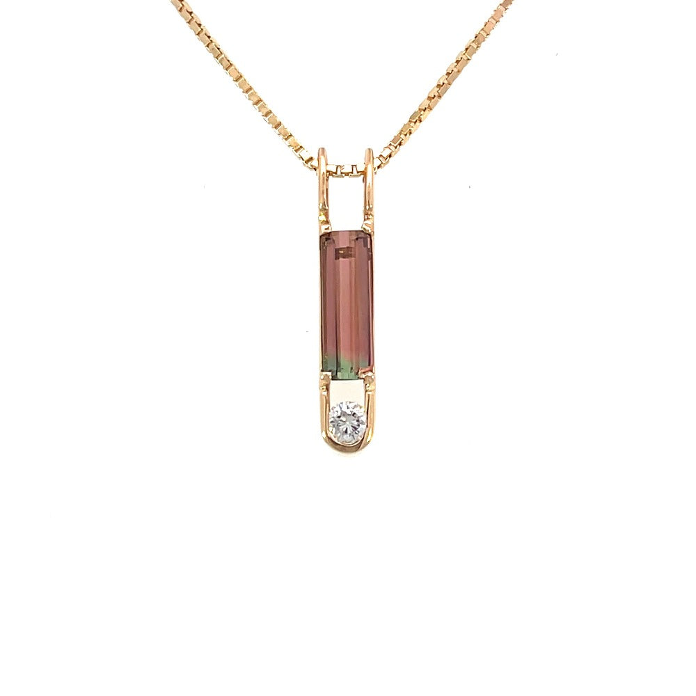 close up view of bi-colored tourmaline and diamond pendant set in yellow gold on a box chain