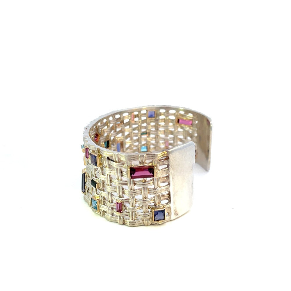 side view of silver and gold cuff bracelet with colored gemstones