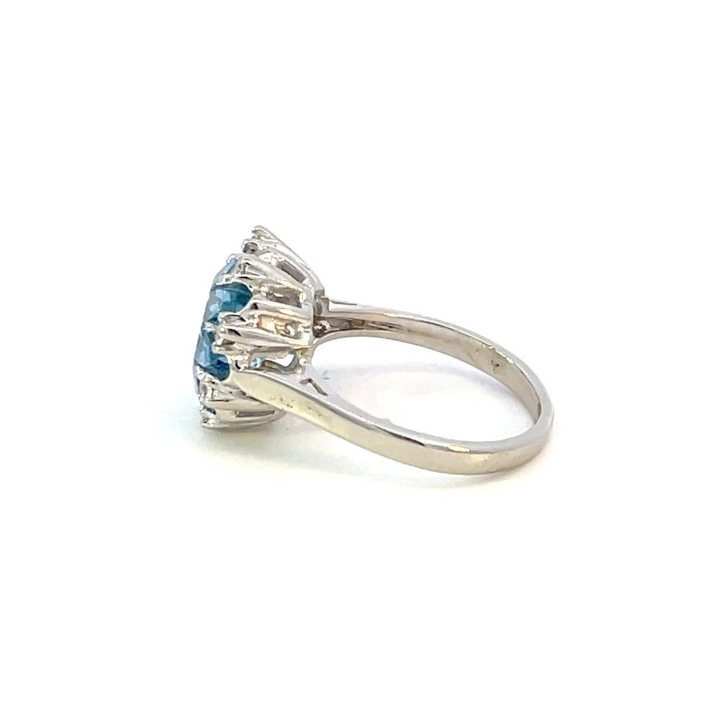 side view of 14k white gold ring with flower cut blue center stone and white stone accents