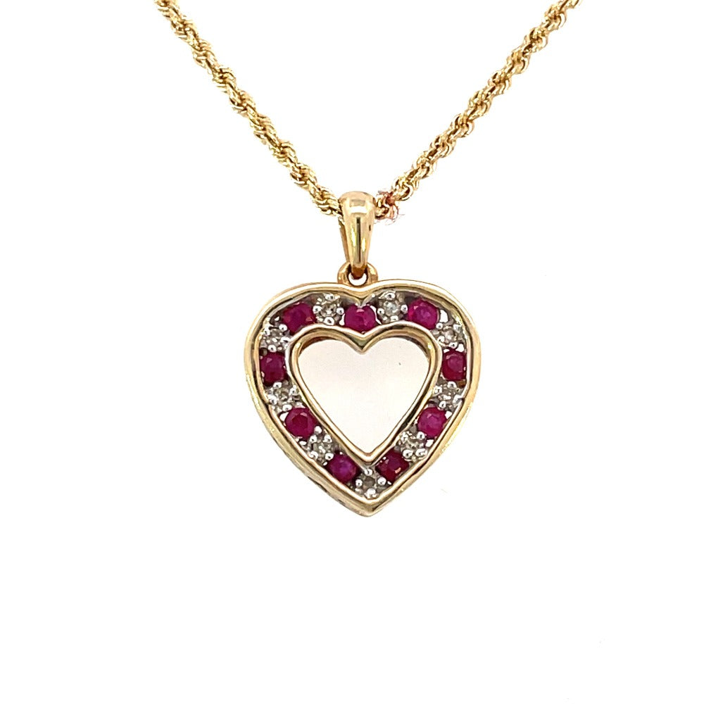 Front view of heart shaped diamond and ruby pendant set in yellow gold on a rope chain