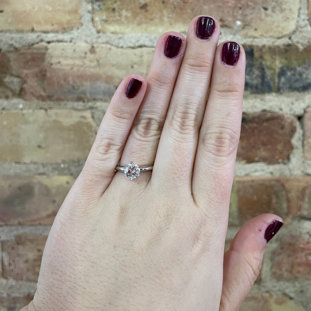 1.11 carat round diamond solitaire engagement ring on the hand of a model