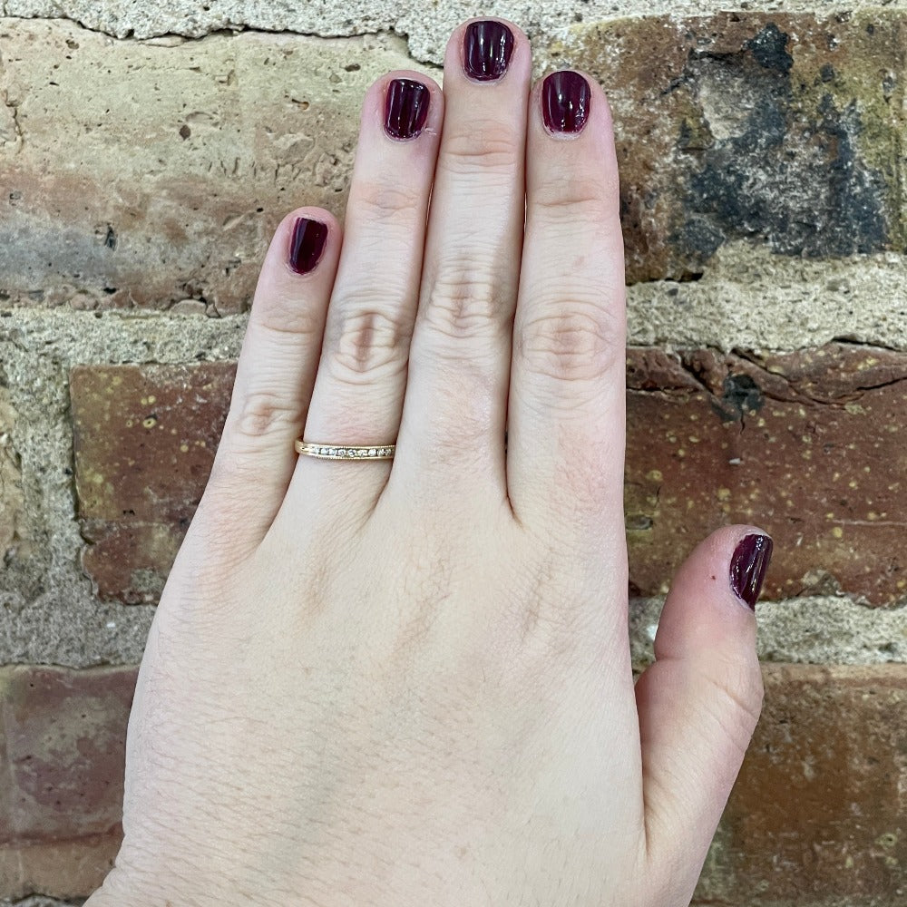 gold band with beaded edge and diamonds on model's hand