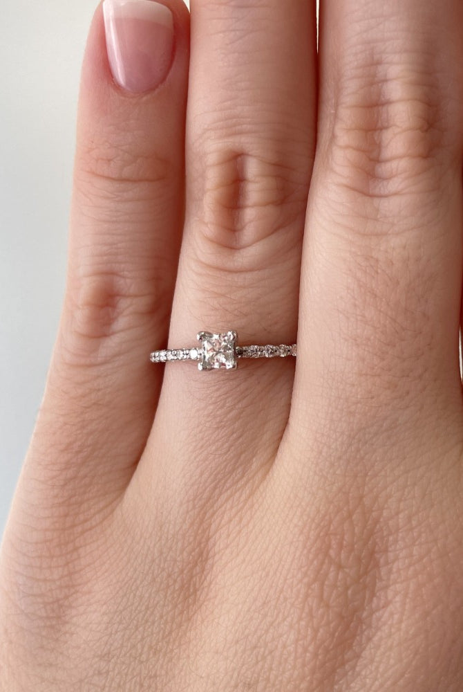 princess cut diamond engagement ring with shared prong band on model.