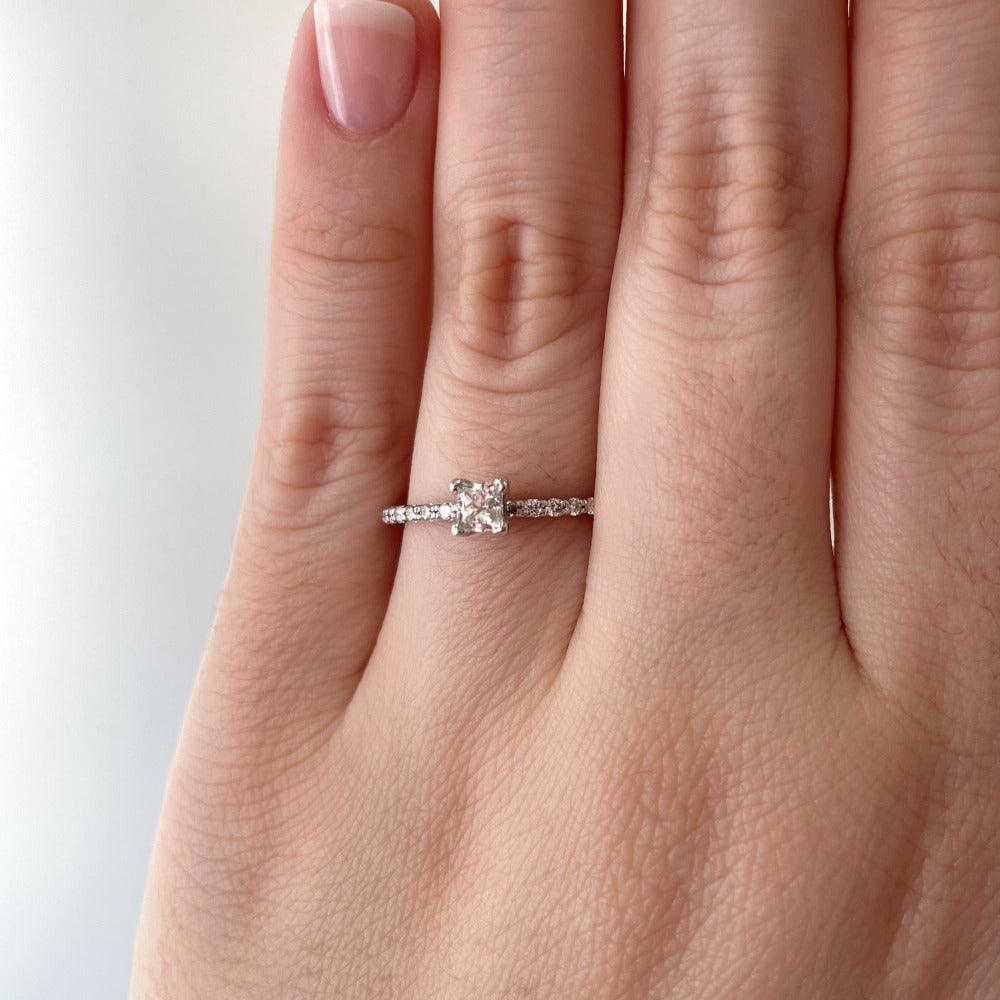 princess cut diamond engagement ring with shared prong band on model.