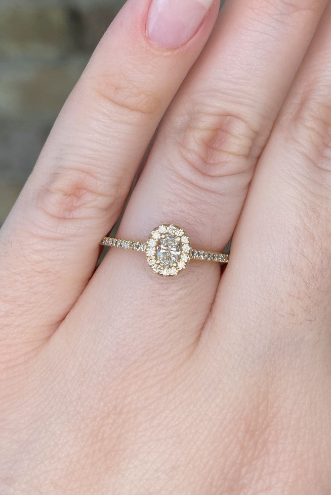 closer view of 14ky oval halo style engagement ring on model