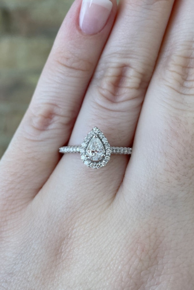 14kw pear shaped halo style engagement ring on model