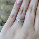 14kw pear shaped halo style engagement ring on model