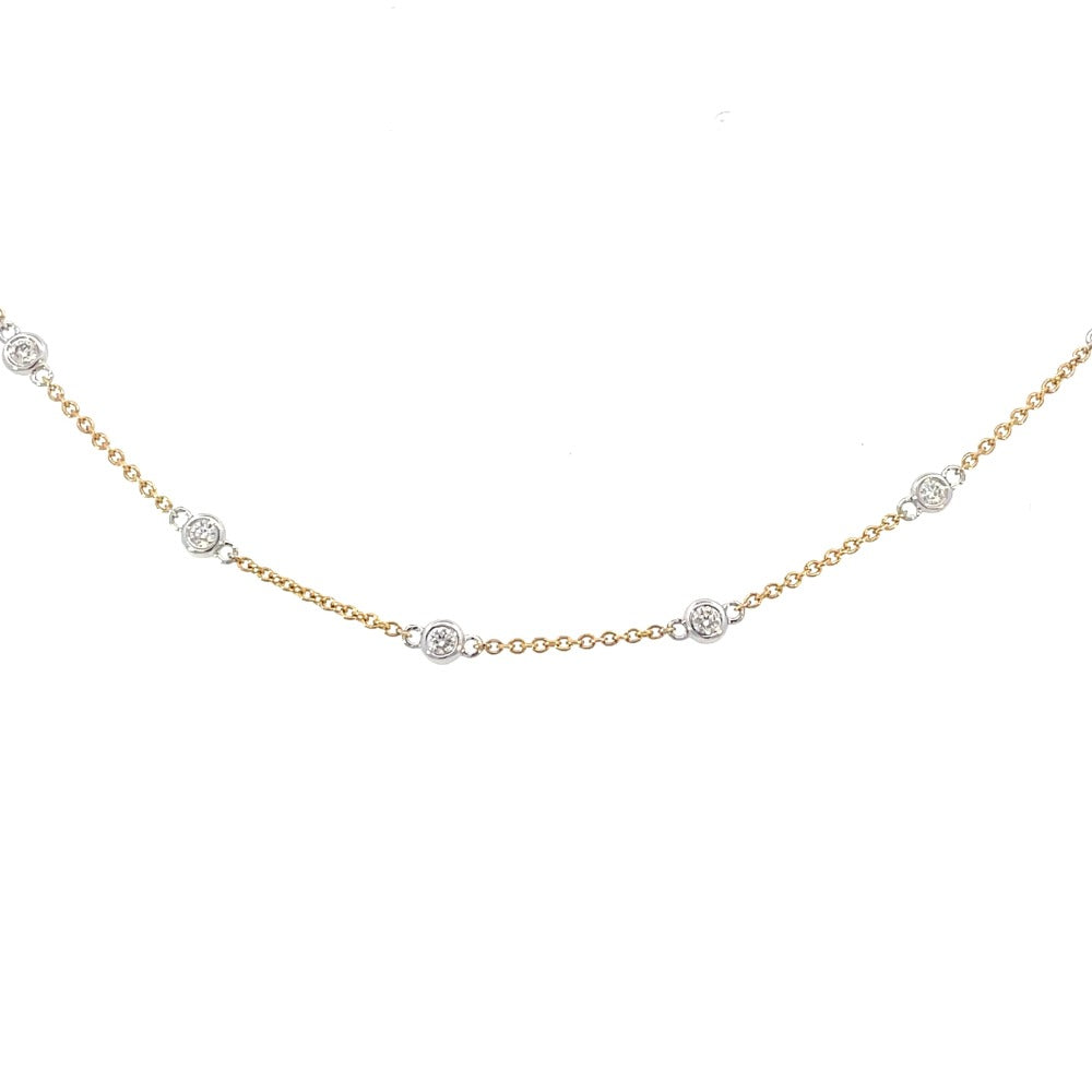 detail view of 14k two-toned gold anklet with bezel set diamond stations.