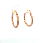 View of 15mm 14K rose gold hoop earrings that shows the thickness of the metal.