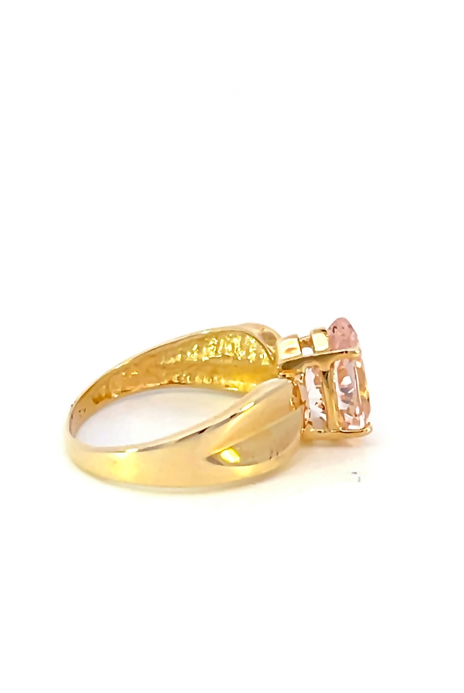 side view of 10 karat yellow gold wide band ring with pear cut pink center stone