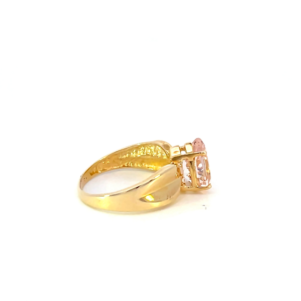 side view of 10 karat yellow gold wide band ring with pear cut pink center stone