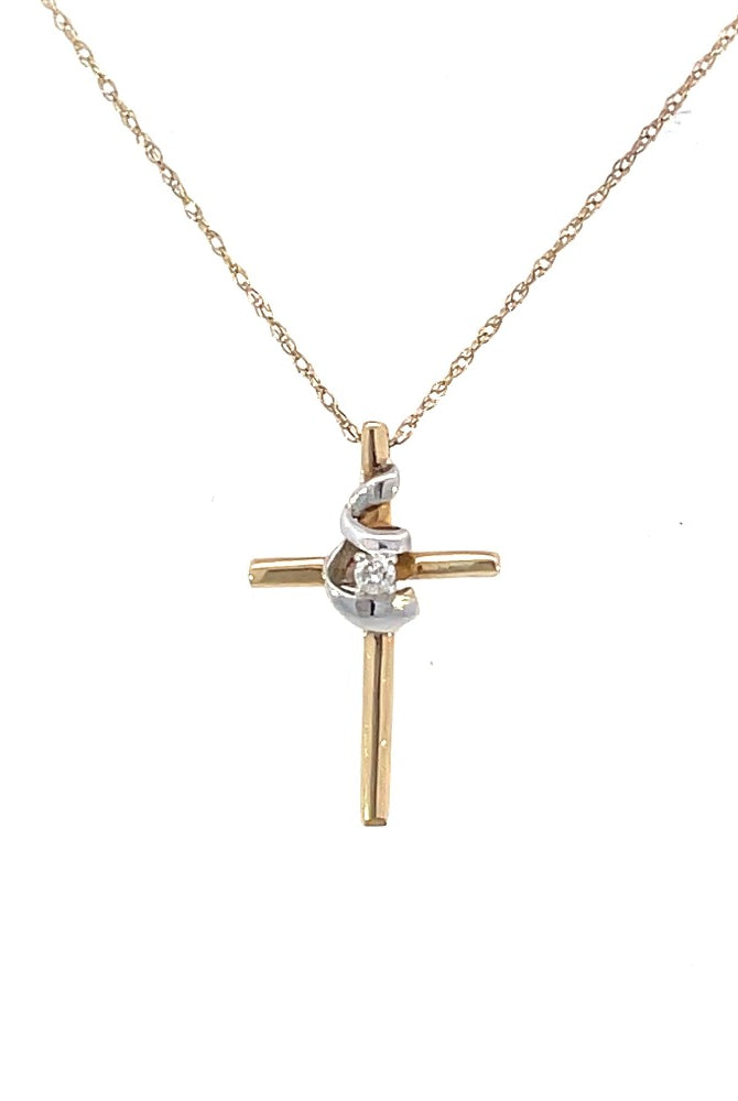 detail view of two-toned gold cross pendant with diamond accent