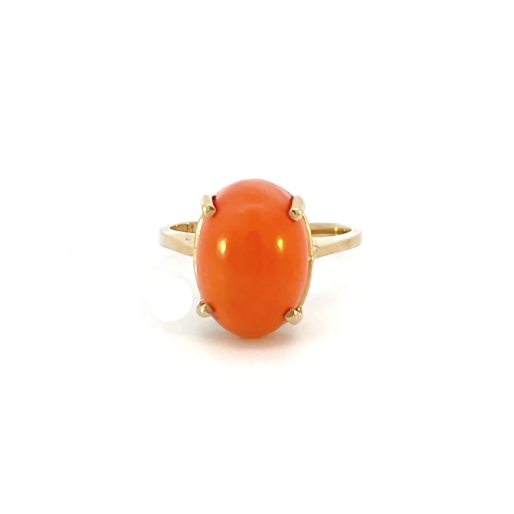 front view of oval cabochon coral ring set in 14 karat yellow gold