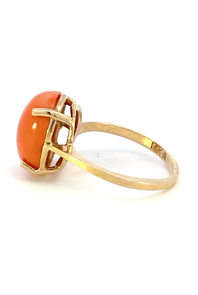 side view of oval cabochon coral ring that shows the 14 karat stamp on the band.