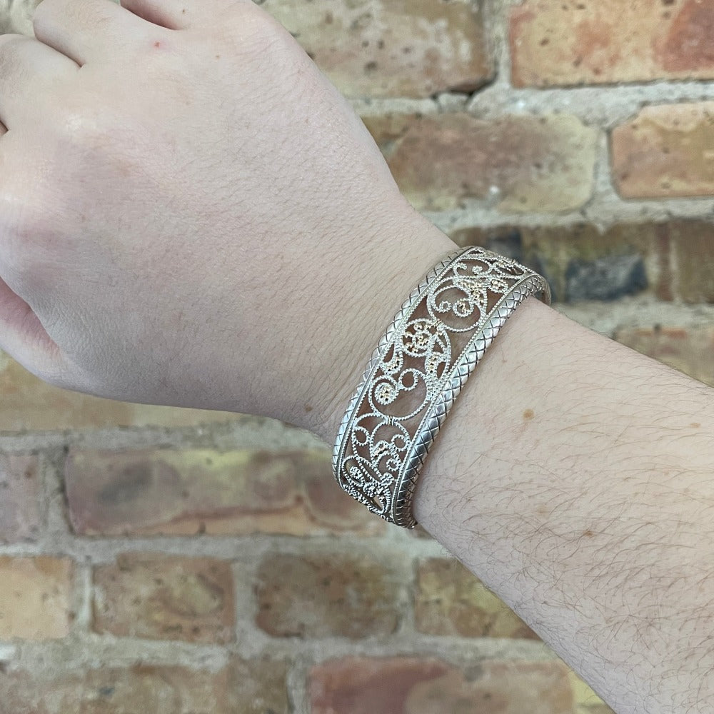 silver and gold filigree bracelet on model's wrist