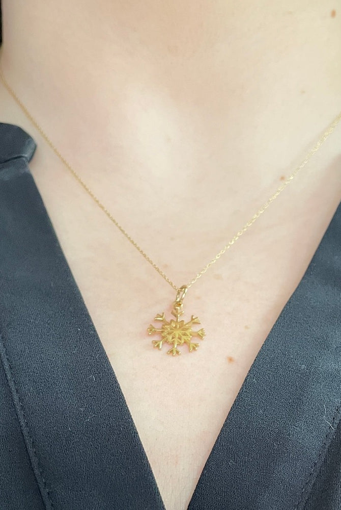 14k yellow gold snowflake pendant on model